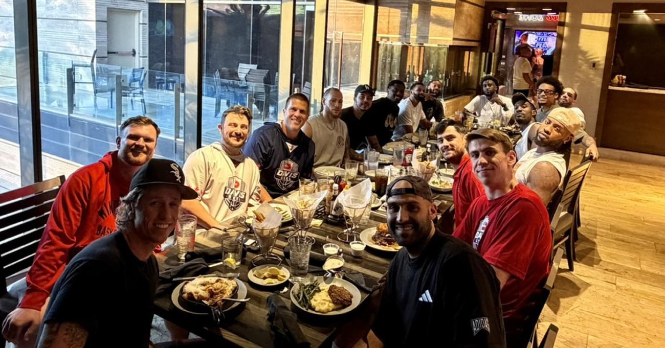 Players and staff around a dinner table