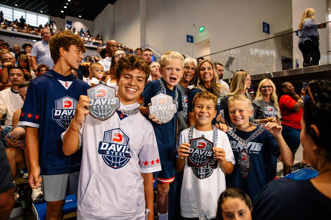 Kids holding Davis Steel medallions in the stands